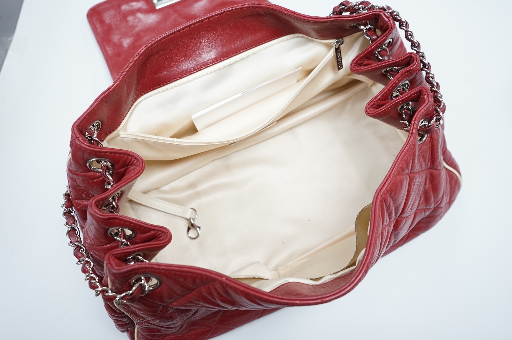 A Chanel East West dark red quilted leather flap shoulder bag with silver hardware, date code 12115484, with original receipt, dust cover and box, 35cm wide, Provenance: purchased by the vendor in Selfridges